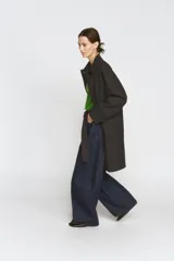 Trench oversize color negro de la colección Zara Woman, confeccionado en hilatura con mezcla de algodón. Presenta cuello solapa, manga larga ajustable con trabillas, bolsillos delanteros y cierre frontal con botones.
