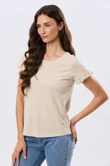 Remera de algodón color verde menta, con escote redondo y mangas corta con detalles de volados sutiles en los puños.