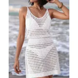 Vestido corto de playa tejido con diseño calado, sin mangas y cuello redondo. Presenta un calce adaptable al cuerpo.