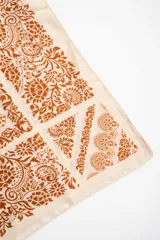 Pañuelo cuadrado de poliéster en tono tostado con un elaborado estampado geométrico y floral en marrón.