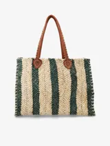 Bolso tipo tote de paja trenzada con diseño a rayas en tonos beige y verde oscuro, asas largas de cuero tostado y costuras visibles en los laterales.