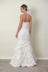 Vestido de novia blanco strapless, con cuerpo drapeado y falda con diseño de flores en tafeta.