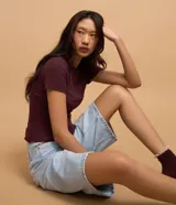 Blusa básica de manga corta y cuello redondo, confeccionada en viscosa texturizada de canalé con elastano y detalle de terminación ondulada en el bajo.