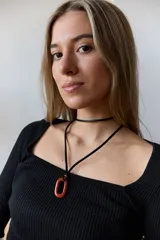 Collar con tiento negro y dije de piedra natural ovalada en tonos grises y azules.