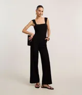 Mono largo de crepé color negro, con escote cuadrado, breteles anchos, bolsillos laterales y cierre trasero con cremallera.