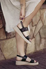 Sandalia de plataforma color beige claro, con dos tiras anchas con estampado de piel de serpiente (pitón) y hebillas metálicas.