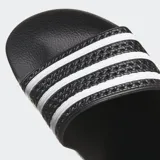 Sandalias Adidas Adilette de color negro con la clásica tira superior texturizada decorada con tres franjas blancas y plantilla contorneada.
