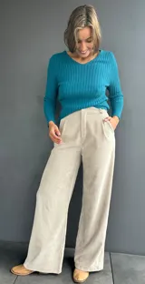 Pantalón de pana en color beige, de corte recto y tiro alto, con pinzas frontales y pretina.
