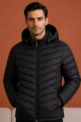 Campera puffer negra con capucha, cierre frontal completo y bolsillos laterales con cierre. Diseño acolchado con costuras horizontales.