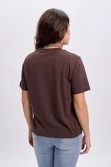 Remera marrón de manga corta con cuello redondo y estampa frontal en color celeste con la leyenda "C'est La Vie Parisien State of Mind".