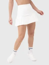 Falda deportiva blanca con short integrado, cintura alta y volados en el ruedo.