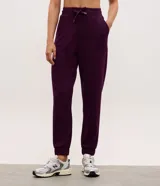 Pantalón tipo jogger de mujer, confeccionado en tejido modal con mezcla de poliéster y elastano. Presenta cintura elástica con lazo de ajuste, bolsillos laterales y puños elásticos en el ruedo.