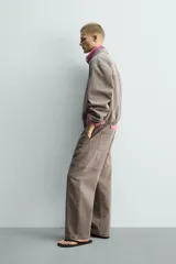 Cazadora de algodón de corte relajado, color marrón grisáceo con efecto lavado. Presenta cuello solapa con tachas metálicas, cierre frontal de cremallera, bolsillos de plastrón en la cadera y puños y bajo elásticos.