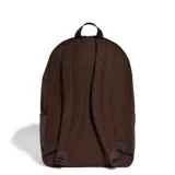 Mochila Adidas modelo Ess Camo, color marrón oscuro, con gran compartimento principal y bolsillo frontal con cierre. Presenta el nombre de la marca en la parte superior con diseño de camuflaje en tonos beige y marrón, acompañado de las clásicas tres franjas verticales en el bolsillo delantero.