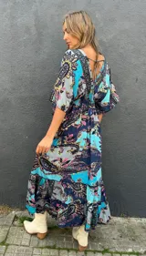 Vestido midi de seda con estampado paisley en tonos turquesa, azul marino, rosa y amarillo. Cuenta con mangas cortas fluidas y diseño amplio.
