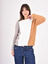 Buzo de tejido de punto con diseño tricolor, presentando un panel central en color blanco, una manga en color gris y la otra manga junto con el lateral en color tostado. Posee cuello redondo y puños acanalados.