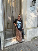 Conjunto compuesto por un remerón negro de algodón con estampa fotográfica frontal y una pollera midi de satén con estampado animal print de leopardo.