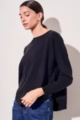 Sweater de tejido de punto en color negro, con corte oversize, cuello redondo y mangas largas con puños acanalados.