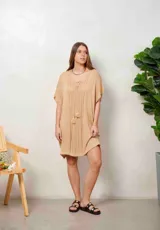 Poncho de hilo tejido en color blanco, con diseño translúcido, escote en V con cordones y borlas colgantes, y mangas murciélago amplias.