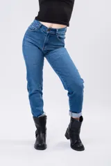 Jean mom de tiro alto con corte recto, confeccionado en denim azul clásico. Presenta cierre frontal con botón y bolsillos laterales y traseros.