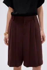 Short ancho de poliéster color negro, de tiro alto y diseño sastrero con pinzas en el frente.