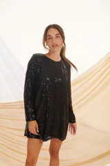 Minivestido negro con lentejuelas, de corte suelto y manga larga.