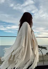 Ruana color crudo de tejido artesanal en telar manual con hilado zigzag y flecos.