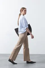 Pantalón de mujer color beige, de corte recto y tiro alto, con costuras frontales marcadas que recorren la pierna.