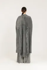 Blazer largo tipo guardapolvo de lino puro color gris con mangas caídas, solapas, cierre de un botón y bordes deshilachados.