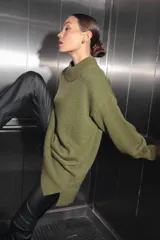 Sweater verde oliva de tejido de punto con cuello polo, mangas largas y corte oversize. Presenta un parche con monograma en la espalda.