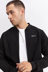 Campera tipo bomber color beige, con cierre frontal completo, cuello redondo y puños elásticos. Presenta una textura sutil en la tela y un calce cómodo.