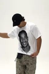 Remera blanca de corte boxy y diseño oversize, con estampa fotográfica frontal en blanco y negro del futbolista Ronaldinho.