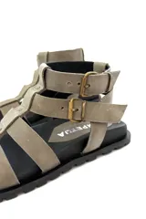 Sandalias de cuero color visón con múltiples tiras y hebillas de ajuste. Suela de goma negra. Diseñadas y hechas en Uruguay.