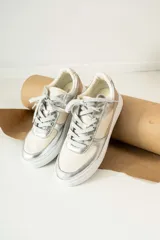 Championes de cuero sintético color beige con detalles plateados.