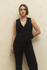 Conjunto sastrero negro compuesto por un chaleco con escote en V y pantalón de vestir de corte recto y tiro alto.