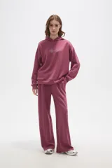 Canguro con capucha de calce holgado, color bordó, con detalle de aplique de strass en el pecho.