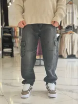 Pantalón cargo de jean gris con efecto acid wash, corte holgado, bolsillos laterales en las piernas y costuras reforzadas.