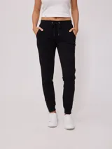 Pantalón deportivo tipo jogging color negro, confeccionado en 60% algodón y 40% poliéster, con cintura elástica ajustable con cordón, bolsillos laterales y puños ajustados con cierre en los tobillos.