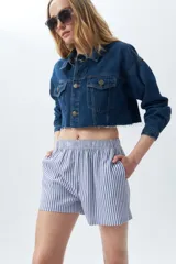 Short a rayas verticales azules y blancas, con cintura elástica y bolsillos laterales.