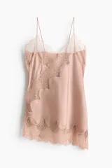 Top largo de satén rosado con breteles finos ajustables, escote en V y diseño asimétrico decorado con ribetes de encaje floral.