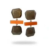 Aros colgantes de diseño geométrico, compuestos por dos piezas de resina color visón con acabado marmolado y una pieza central rectangular en color naranja vibrante. Cuentan con herrajes dorados y cierre tipo clip.