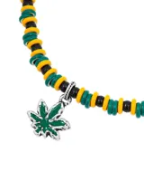 Collar de cuentas de colores verde, amarillo y negro, con dije de hoja de marihuana plateada.