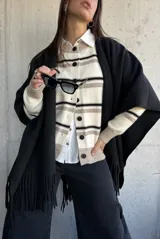 Ruana de tejido de punto en color bordó, con diseño abierto y terminación de flecos en los bordes.