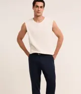 Pantalón de vestir azul marino, de corte relajado, confeccionado en tejido de viscosa y lino. Cuenta con cintura con trabillas, bolsillos laterales y traseros. Se ajusta a la cintura con cinturón de cuero marrón.