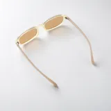 Lentes de sol con armazón rectangular de acetato color beige claro y cristales marrones con protección UV400.