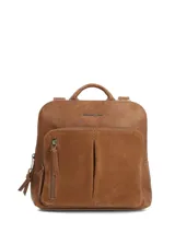 Mochila Hush Puppies color caramelo con bolsillo frontal grande de gamuza sintética y cierre principal. Presenta asas superiores y tiras ajustables traseras.