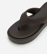 Ojotas negras con plataforma plana, tiras anchas y puntera redonda.