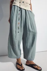 Pantalón barrel negro confeccionado en 100% lino, con tiro medio y cintura elástica fruncida. Cuenta con bolsillos laterales y falsos bolsillos de vivo en la espalda, de corte amplio y holgado.