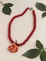Collar con cuentas de piedras naturales rojas y dije de porcelana en forma de hoja con detalles multicolor, cierre de acero quirúrgico.