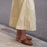 Zueco de cuero color marrón, con diseño fruncido en el empeine, punta cuadrada y taco bajo de madera.